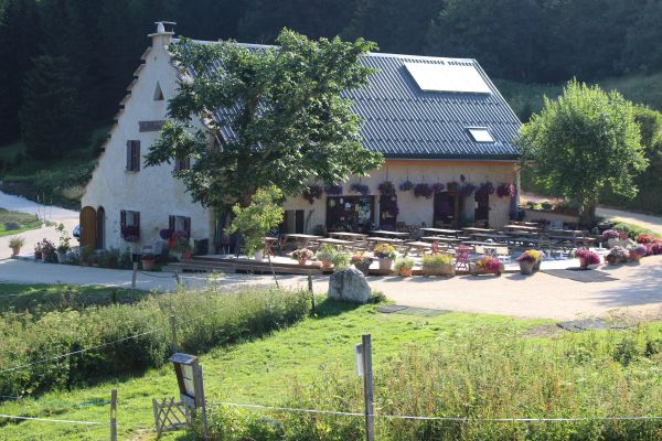 vue de l'auberge en t avec sa terrasse fleurie